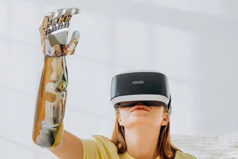 Lady with bionic arm and virtual reality headset in room Stock Photos