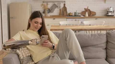 Lady with bionic arm looks through social media via phone Stock Footage 150242778