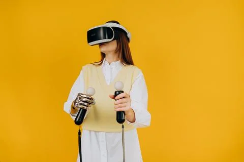 Lady with bionic arm virtual reality goggles and joysticks Stock Photos