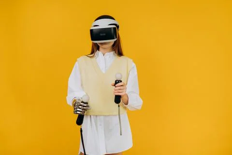 Lady with bionic arm virtual reality goggles and joysticks Stock Photos