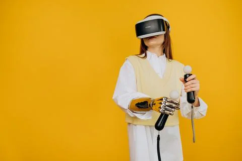 Lady with bionic arm virtual reality goggles and joysticks Stock Photos