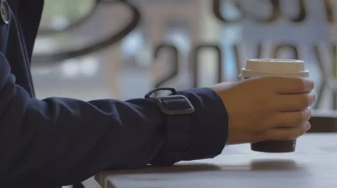 Lady in blue coat drinking coffee against the window Stock Footage 67052091