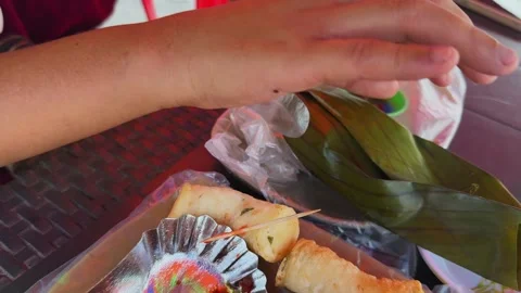 Lady carefully unwraps corn leaf revealing steamy baked rice Stock Footage 308916220