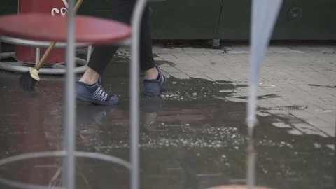 Lady cleaning ground front of restaurant Stock Footage 71218179