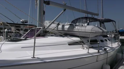 Lady climbing aboard docked sailing yacht with dinghy lashed to deck. Stock Footage 67517873