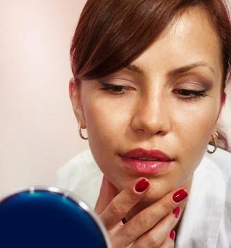 Lady with compact mirror Stock Photos