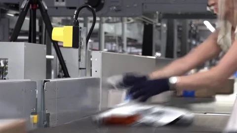 Lady correcting parcels on conveyor - time lapse motion blur 스톡 동영상 83628225