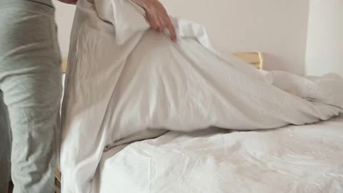Lady covers large bed with blanket keeping order at home 動画素材 160710642
