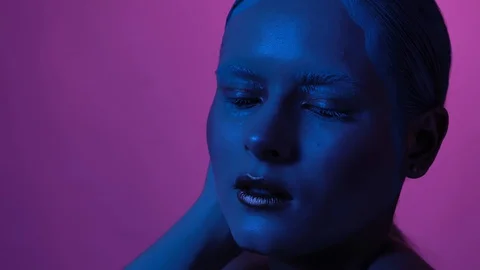 Lady with creative makeup is shining in neon lights and Stock Footage 130128265