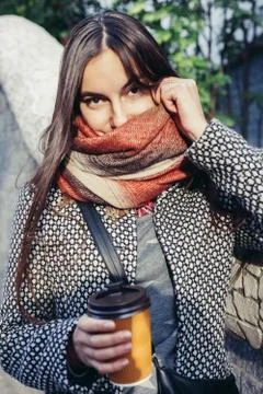 Lady with a cup of coffee walking down the city street Stock Photos
