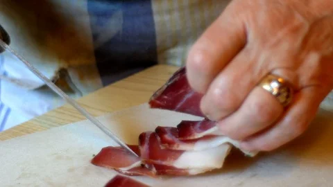Lady cuts the speck into small cubes for the preparation of Tyrolean dumplings Stock Footage 112655108