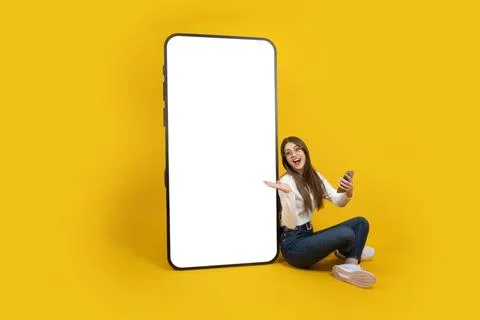 Lady demonstrating empty blank screen big smartphone mockup. Copy space. Stock Photos