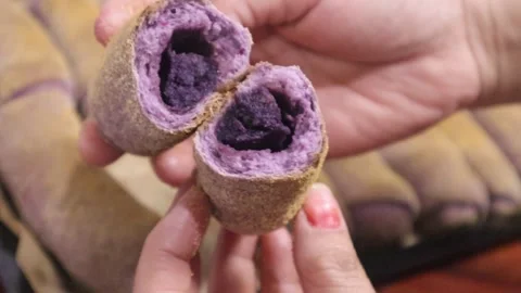 Lady displaying UBE spanish bread Stock Footage 329935027