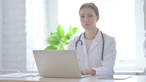 Lady Doctor Looking at Camera While sitting in Clinic Stock Footage 204999996