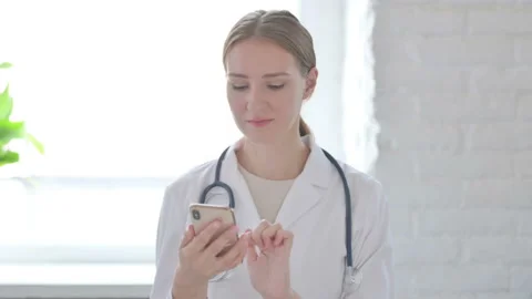 Lady Doctor using Smartphone for Browsing Internet Stock Footage 205001073