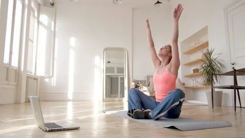 Lady does forward bends according to video tutorial on floor Video stock 150082628