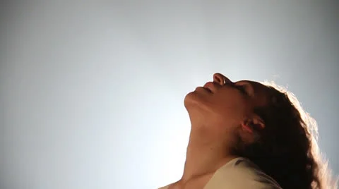 Lady does a head shake movement back of the bright full light Stock Footage 22789837