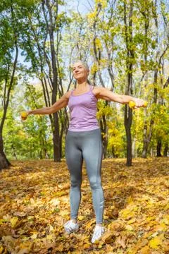 Lady doing an arm exercise using dumbbells Foto stock