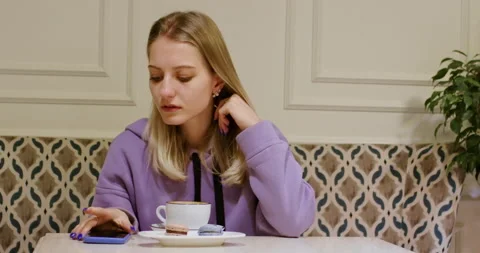 Lady drinks coffee getting disappointed after checking phone Stock Footage 208954557