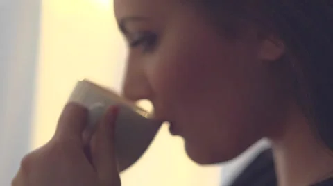 Lady enjoying cup of steaming beverage over beautiful sunset at home. Vídeo Stock 50051387