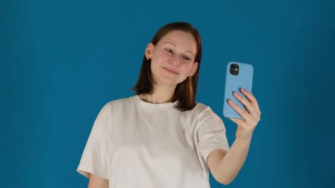 Lady experiments with poses and expressions on blue background Stock Footage 272297441