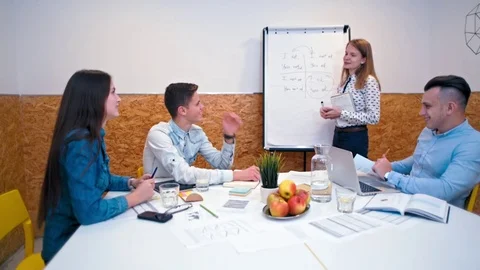 Lady is Explaining Theory to a Group of People near Flipchart in an Office Room Stock Footage 83997982