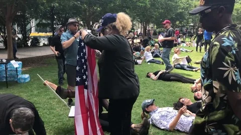 Lady folding the US flag during anti-gun rally in Atlanta Stock Footage 76836081