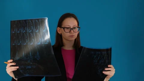 Lady in glasses compares X-ray scans to advance in treatment Stock Footage 272767202