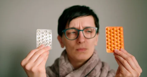 Lady with glasses holding tablets strap and confused to chose between them Stock Footage 127127399