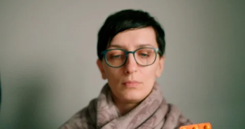 Lady with glasses holding tablets strap  and trying to chose between them Stock Footage 127191058