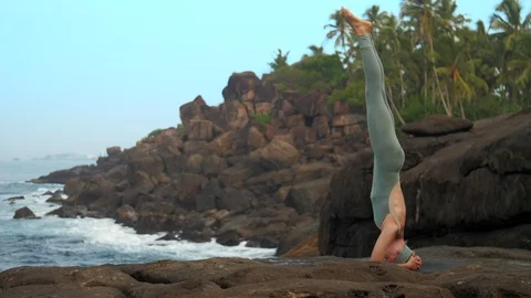 Lady in grey does yogic headstand on flat rock slow motion Vidéo 112267114