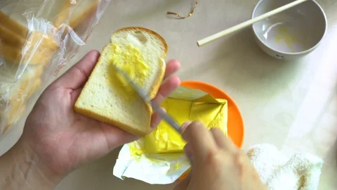 Lady hand Spreading Butter on bread Video stock 127945566
