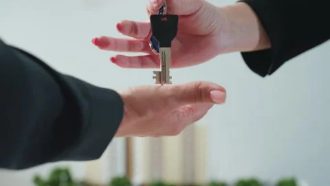 Lady Handing Over Key with Building Model in Background Stock Footage 310810916