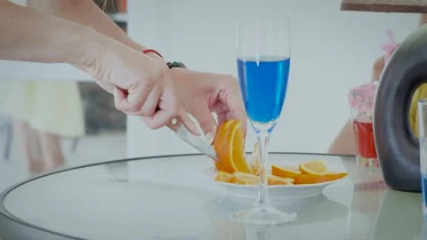 Lady hands cut orange on table among beverages closeup Stock Footage 138053035