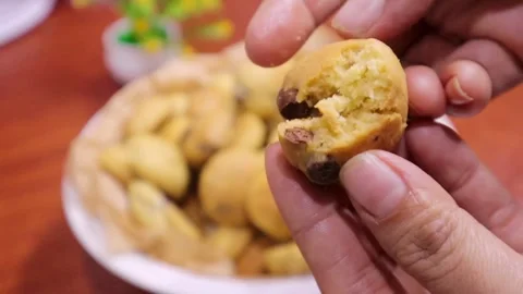 Lady hands showing in camera chocolate chip cookies and craking it for demo Stock Footage 328723630