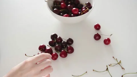 Lady hands take red cherry from white bowl young woman eats Vídeo Stock 160105189