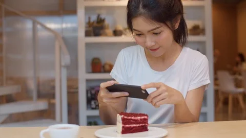 Lady happy relax fun using technology mobile phone taking a photo of her cake. Stock Footage 119352228