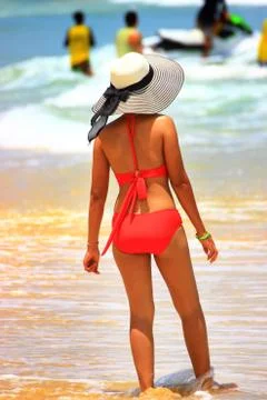 The lady in the hat in the shallows of the beach Stock Photos