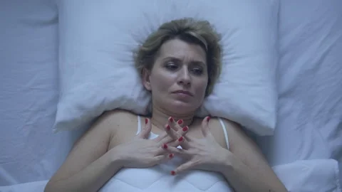Lady in her 50s lying in comfortable bed, and trying to fall asleep, need rest Stock Footage 255129534