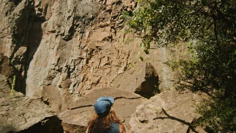 Lady hiking to arrive at bottom of forest waterfall Stock Footage 152799172