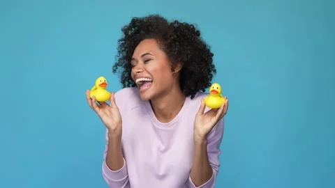 Lady hold crazy yellow plastic ducks laugh isolated blue color background Stock Footage 167358193