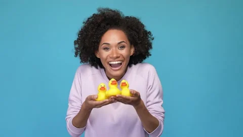 Lady hold hand yellow plastic ducks game isolated blue color background Stock Footage 167358296