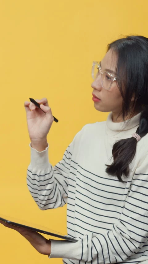 Lady holding tablet computer and pointing finger up at copy space. Vídeo Stock 347202579