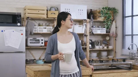 Lady holding tea standing propping against table Stock Footage 151807664