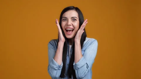 Lady impressed hands up win scream isolated on mustard color background Stock Footage 165453422
