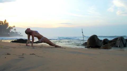 Lady improves endurance performing reverse plank on beach Stock Footage 274724083