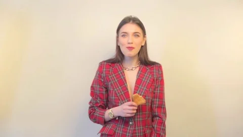 Lady in jacket eats cookies and smiles Stock Footage 73367712