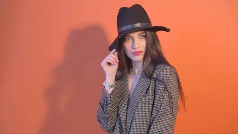 Lady in jacket touches the hat and posing Stock Footage 73358104