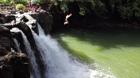 Lady Jumps off Cliff into Lagoon Stock Footage 4223367