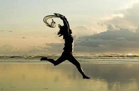 Lady leaps at sunset. Stock Photos